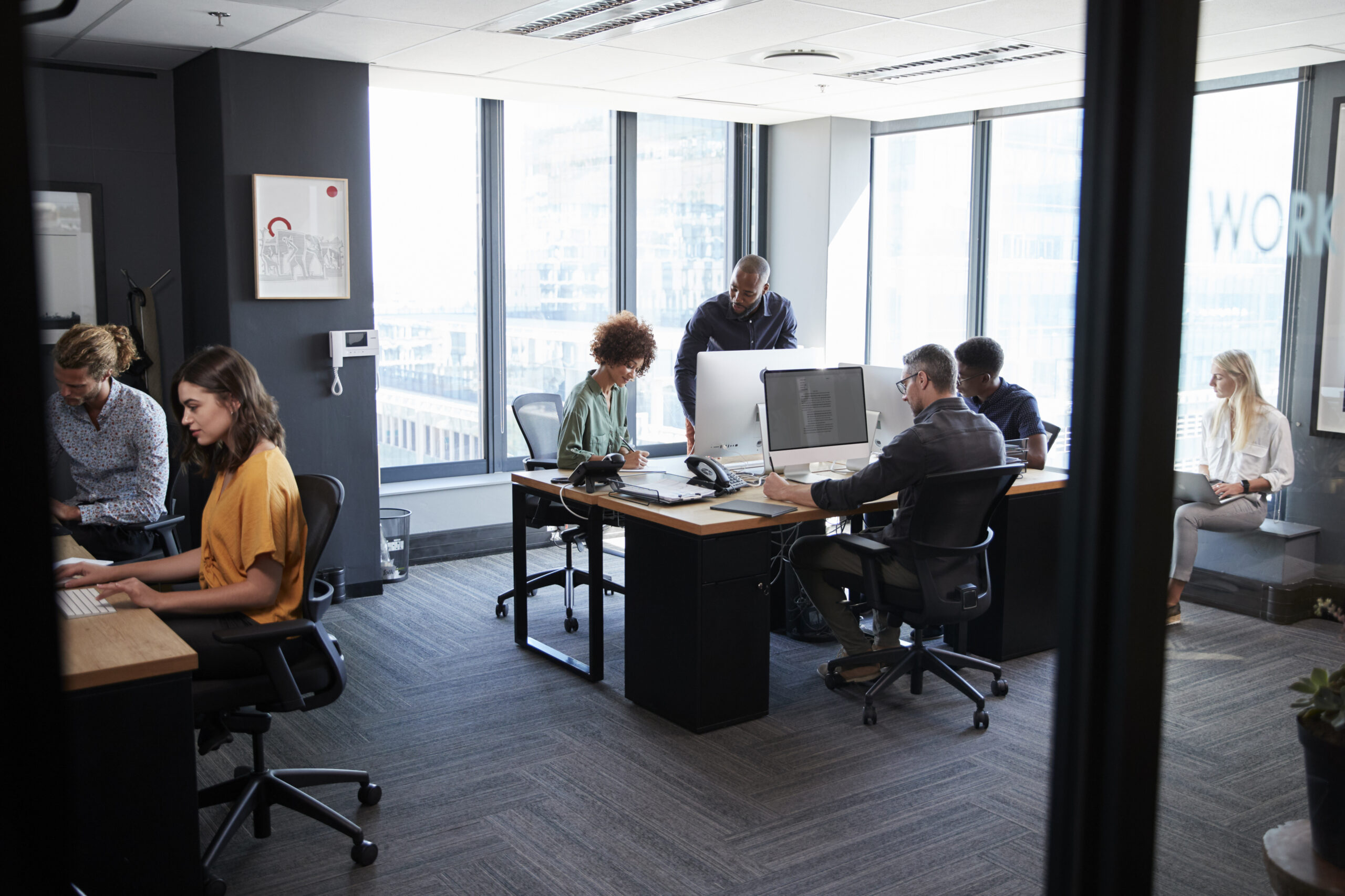 Professionals working together in a modern office, capturing the daily operations of a results-driven direct marketing agency.